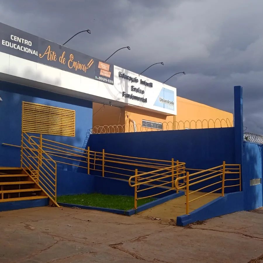Fachada da escola, em azul e amarelo, com o letreiro Centro Educacional Arte de Ensinar