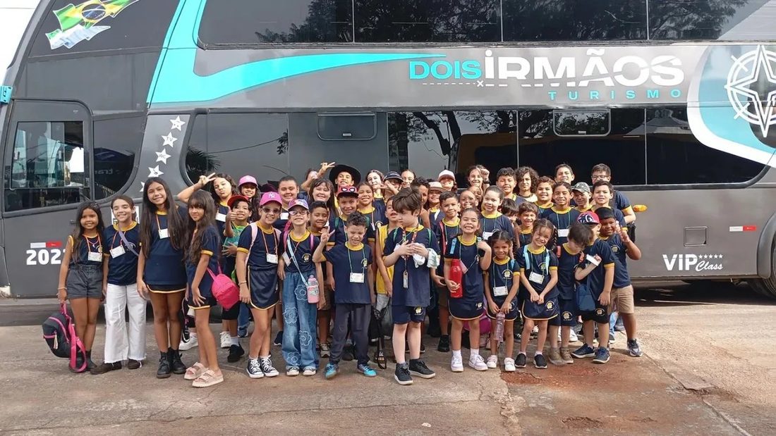 Alunos do Centro Educacional Arte de Ensinar, de uniforme azul e amarelo, reunidos antes de uma excursão